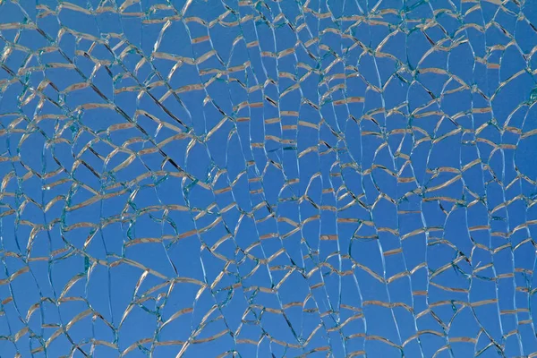 Sprickor i glaset. Spraka mosaik blå bakgrund. — Stockfoto