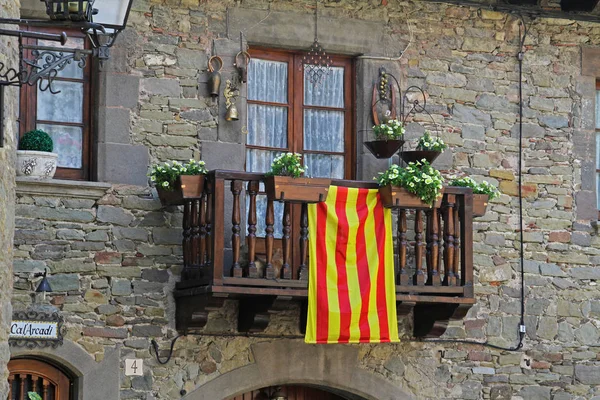 Balkón s bílými Petúnie a Katalánská vlajka ve městě Rupit — Stock fotografie