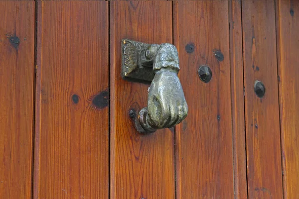 Door knocker in the form of a hand on wooden door in Rupit — Stock Photo, Image
