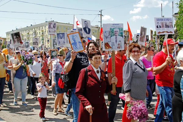 La gente tiene retratos de sus parientes en la acción "Regimiento inmortal" el día de la victoria en Volgogrado —  Fotos de Stock