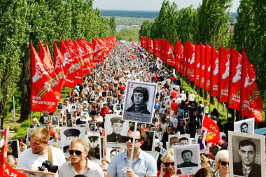 Procession of local people with photos of their relatives in Immortal Regiment on annual Victory Day on Mamaev Hill in Volgograd clipart