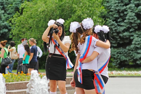 Mädchen in Schuluniform, die Schleifen und das Band "Absolventin" bilden ein Bild zur Erinnerung an die Feier des letzten Aufrufs in Wolgograd — Stockfoto