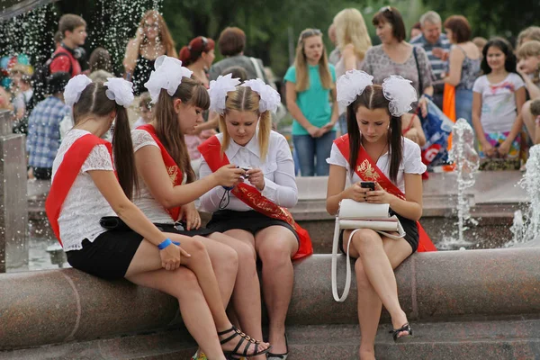 Filles en uniforme scolaire, les arcs et le ruban "Graduate" sur la célébration du dernier appel à Volgograd — Photo