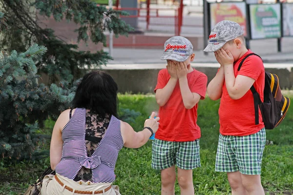Mère pulvérisation insectifuges sur les enfants avec vaporisateur bouteille à Volgograd — Photo