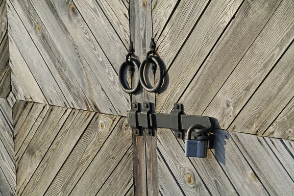 Metal handle and hasp with lock on wooden doors of the gate. — Stock Photo, Image