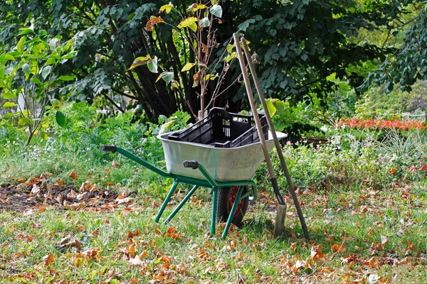 Wheelbarrow full of boxes and gardening tools in the park — Stock Photo, Image