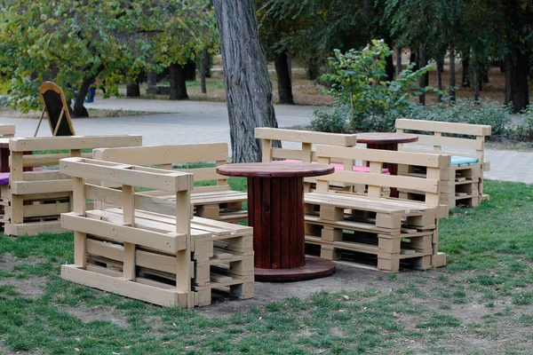 Houten bankje gemaakt van pallets voor zitten met tabellen gemaakt van spoel van elektrische kabel — Stockfoto