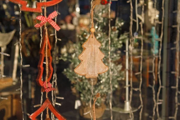 Brinquedo de madeira árvore de natal pendurado na janela da loja — Fotografia de Stock