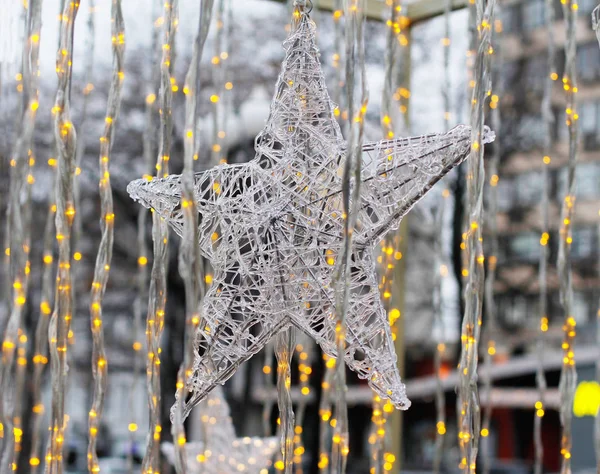 Juguete de Navidad en forma de estrella colgando en el fondo de luces doradas — Foto de Stock