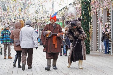 Moscow, Russia - February 25, 2017: Buffoon with balalaika and bear at Russian national festival 