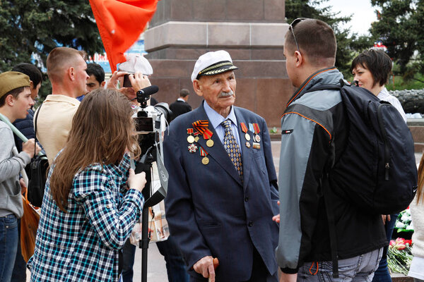 Volgograd, Russia - May 09, 2017: People interview a veteran of world war II on the Square of the Fallen Fighters in Volgograd