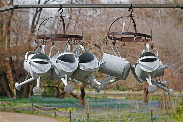 Metal steel watering cans hanging on the dryer outdoors — Stock Photo, Image