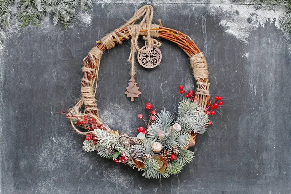 Christmas wreath hanging on a black chalk board