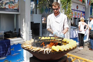 Moskova, Rusya - 29 Mayıs 2019: Şef Moskova 'da düzenlenen Balık Haftası festivalinde ızgarada balık ve mısır pişiriyor