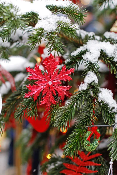 クリスマスツリーの枝にぶら下がっている赤いおもちゃの雪のフレーク — ストック写真