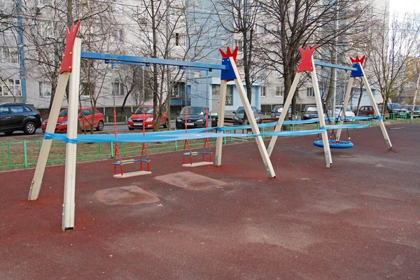 Vidnoe (Moskova bölgesi), Rusya - 12 Nisan 2020: Vidnoe avlusundaki COVID-2019 salgınından dolayı çocuk salıncağı mavi bir banta sarıldı