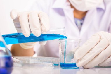 Bilim adamları kimyasallarla deney yapıyorlar. Bilimsel deney tüpü kamera mikroskobu kimya hakkında bilimsel makalelerde ya da kitaplarda kullanılabilir. Bilim adamları Asyalı kadınlardır. .