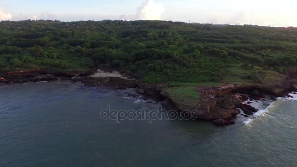 Vliegen boven de golven langs de rotsachtige kust in Bali, Indonesië — Stockvideo