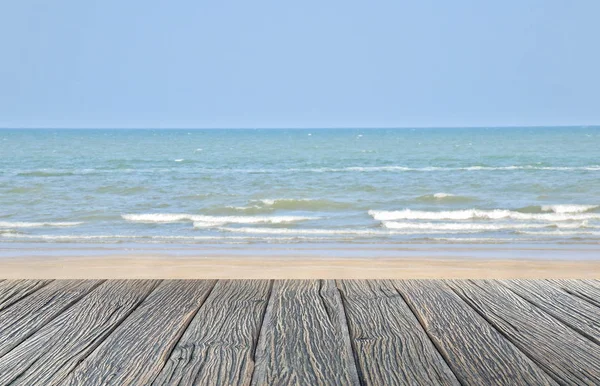 Wood floor on sand beach and tropical sea with blur jet ski solf focus