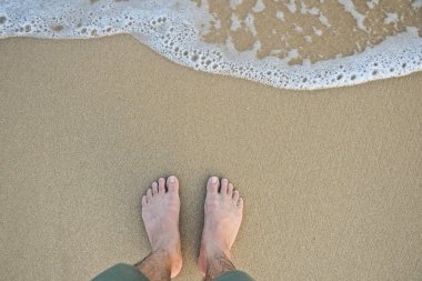ayak kumlu plaj üstte dalga ile göster