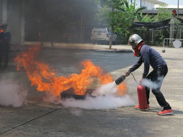 İnsanlar hazırlık Yangın tatbikatı ve bir yangın emniyet tank kullanmak için eğitim için.