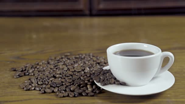 一杯有豆子的热咖啡的大镜头 木桌作为背景 — 图库视频影像
