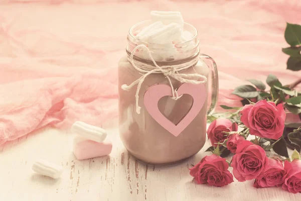 Cocoa with marshmallows and a bouquet of roses. concept of Valen