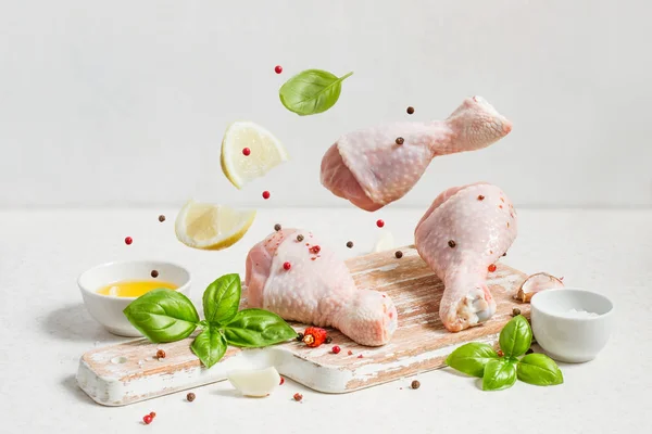 Raw chicken drumstick And spices fly over the cutting board, cop