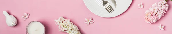 Spring flowers banner. Hyacinths and tableware on a pink background
