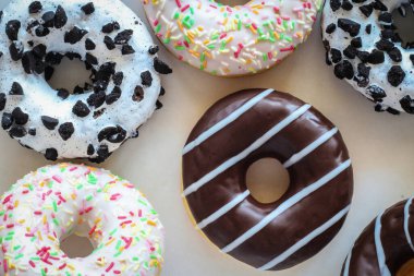 Çikolata kaplı, çizgili donutun düz görüntüsü diğer farklı çöreklerin arasında yatıyordu.