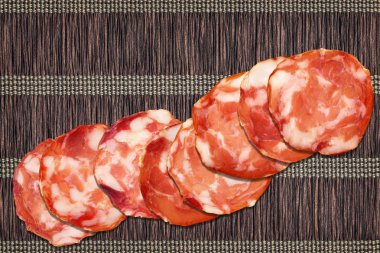 Domuz salamı dilimler iç içe parşömen yer Mat zemin üzerine