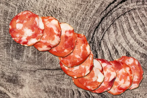 Wieprzowina plasterki Salami na stary stół piknik rustykalny kikut — Zdjęcie stockowe