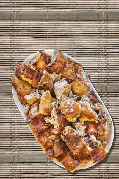 Plateful of Spit Roasted Pork Slices On Straw Place Mat Background — Stock Photo, Image