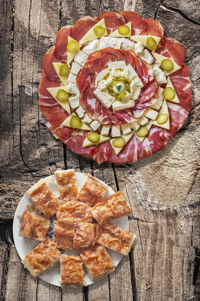 Appetizer Savory Dish Meze With Plateful Of Serbian Traditional Gibanica Crumpled Cheese Pie Set On Old Cracked Wooden Picnic Table — Stock Photo, Image