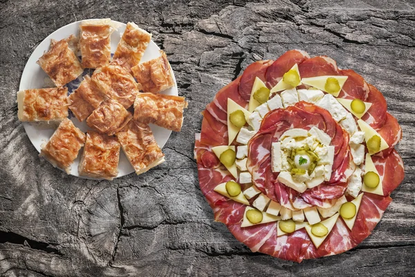 Aperitivo Savory Dish Meze con plato de pastel de queso machacado tradicional serbio de Gibanica en una vieja mesa de picnic de madera agrietada — Foto de Stock