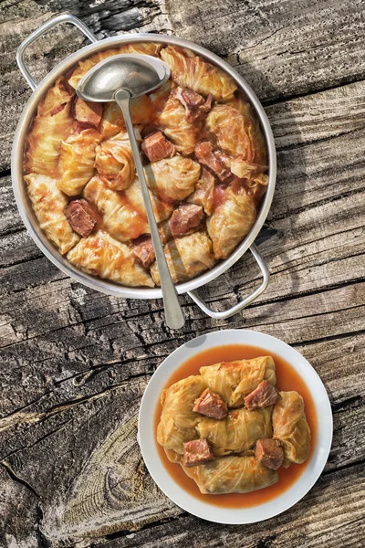 Plateful Of Cabbage Rolls Stuffed With Minced Meat Cooked In Tomato Sauce In Stainless Steel Saucepot Set On Old Wooden Garden Table — Stock Photo, Image