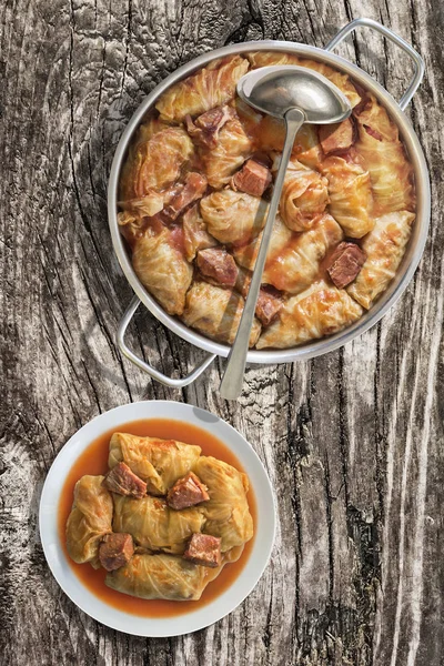 Plateful Of Cabbage Rolls Stuffed With Minced Meat Cooked In Tomato Sauce In Stainless Steel Saucepot Set On Old Wooden Garden Table — Stock Image Plateful Of Cabbage Rolls Stuffed With Minced Meat Cooked In Tomato Sauce In Stainless Steel Saucepot Set On Old Wooden Garden Table Stock Image