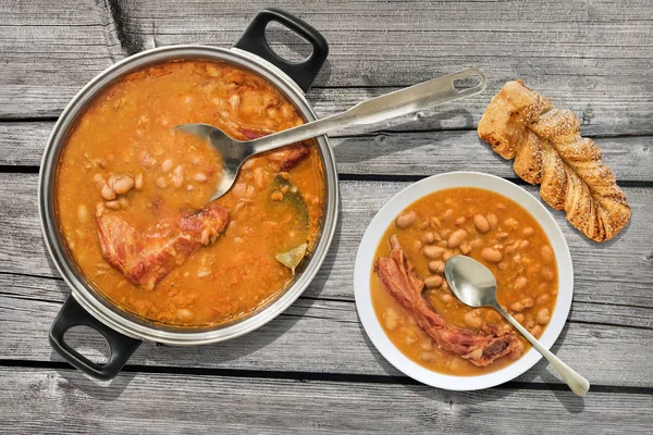 Plateful Of Baked Beans With Smoked Pork Ribs And Sesame Braided Puff Pastry Served On Old Cracked Wooden Garden Table — Stock Photo, Image