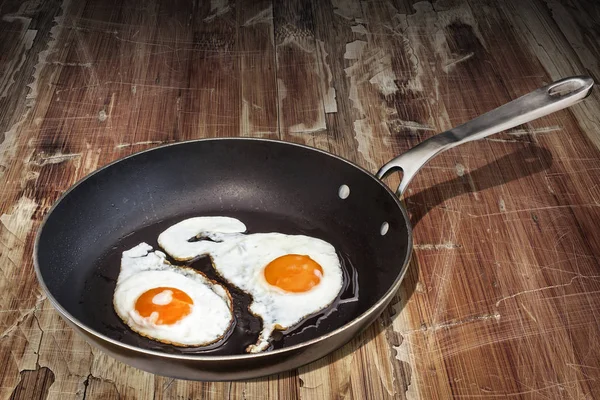 Aferin eski ağır Teflon tavada küme eski kırık lapa lapa ahşap masa üzerinde yumurta kadar güneşli tarafı — Stok fotoğraf