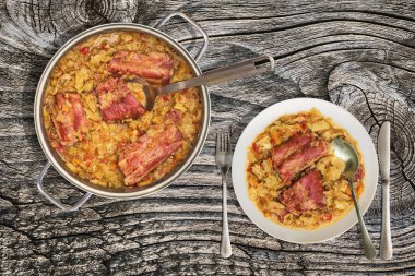 Tabak pişmiş füme domuz kaburga paslanmaz çelik Saucepot eski kırık rustik çam ahşap Bahçe masaya servis yapılan ile lahana