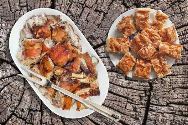 Plateful of Spit Roasted Pork Shoulder Slices and Serbian Crumpled Cheese Pie Gibanica Set on Old Cracked Rustic Stump Picnic Table — Stock Photo, Image