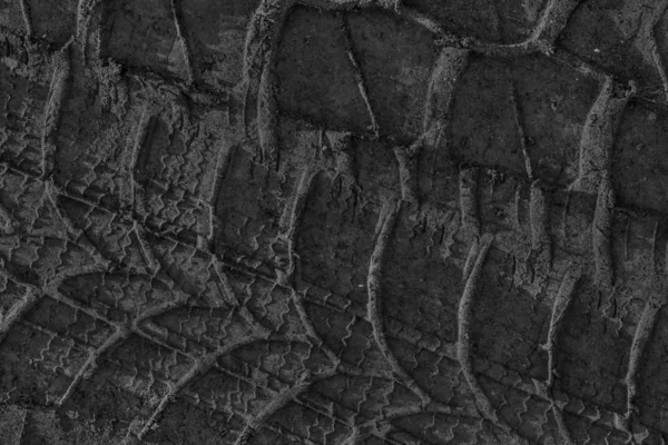 Печать следов шин в грязной грязи с черным песком — стоковое фото