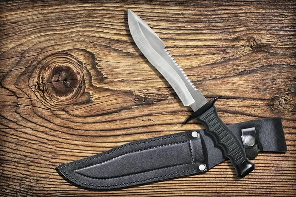 Combat Hunting Survival Sawback Bowie Knife con fodero in pelle nera incastonato su sfondo di legno di pino rustico annodato vecchio — Foto Stock