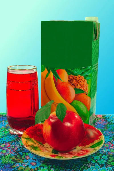 glass and carton of juice, an apple on a platter