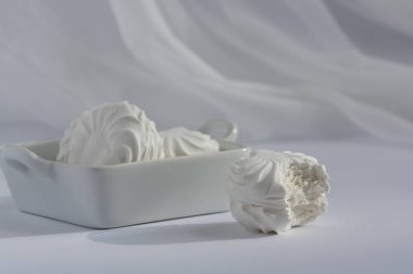 Beyaz arka planda tam kare şekerleme tabağı ile ısırılmış bir lokum. Doğal gün ışığı.