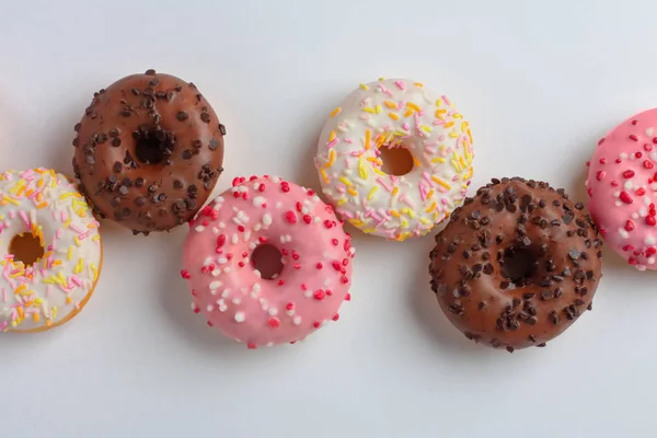 Rosquillas Colores Con Diferentes Esmaltes Una Fila Sobre Fondo Blanco —  Fotos de Stock