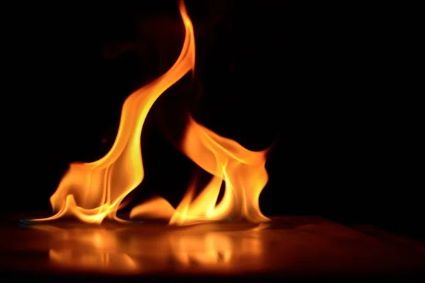 Hermosas llamas de fuego sobre un fondo negro. —  Fotos de Stock