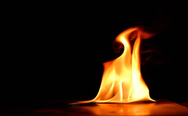 Belas chamas de fogo em um fundo preto. — Fotografia de Stock