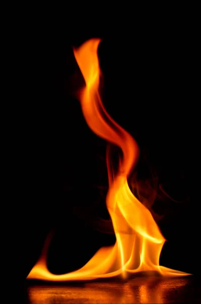 Hermosas llamas de fuego sobre un fondo negro. —  Fotos de Stock