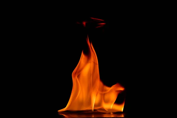 Hermosas llamas de fuego sobre un fondo negro. — Foto de Stock